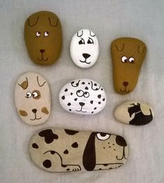 painted rocks with dogs on them are arranged in the shape of heads and paws,