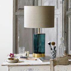 a table with a lamp on top of it and other items sitting on the table