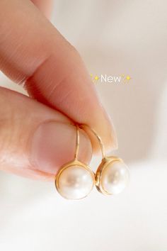 a person holding two pearls in their hand with the word new written on it,