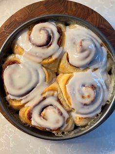 a pan filled with cinnamon rolls covered in icing