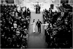 a bride and groom walking down the aisle at their wedding ceremony in black and white