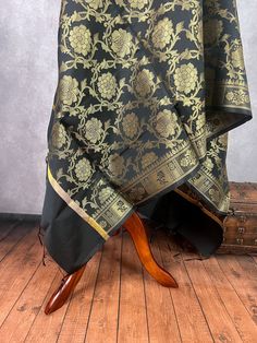 Gorgeous Black Color floral Jaal Banarasi Dupatta with Muted Gold Zari Weave. Dupatta is Soft and will add beauty to any Outfit. Makes a Perfect Gift! Please note - Dupatta has black color tassles on the ends. Item: DupattaColor : Black with Muted Gold Zari Weaving Fabric : Banarasi Silk (Non Pure Silk)Work : Zari Weaved with tassels Length of the dupatta : 88 inches (approx)Width of the dupatta : 35 inches (approx)Store Policies- No return or exchange will be accepted for color variations.- No Black Brocade Dupatta For Wedding, Black Katan Silk Dupatta With Motifs, Festive Black Dupatta For Celebration, Black Dupatta With Traditional Drape, Black Brocade Dupatta With Zari Work, Black Dupatta With Traditional Drape For Transitional Season, Transitional Season Black Dupatta With Traditional Drape, Transitional Black Dupatta With Motifs, Transitional Black Dupatta With Traditional Drape