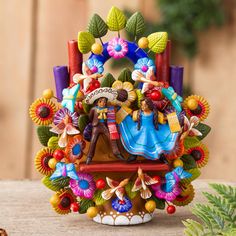 a figurine of a man and woman on a bench surrounded by colorful flowers