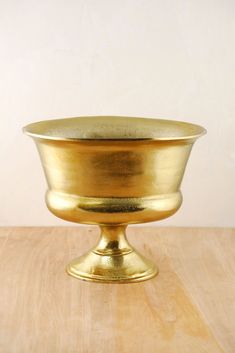 a golden bowl sitting on top of a wooden table