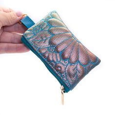 a person is holding a small wallet in their hand