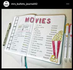 an open notebook with movies written on it and some pens next to it, along with two markers