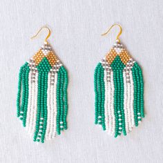 UPAVIM Crafts is excited to announce its brand new seed bead jewelry line with each piece in the collection named after one of the talented artisans who made them! Our Angela Seed Bead Earrings feature green, grey, and white beads threaded in an incredibly delicate and intricate pattern. Lightweight and comfortable to wear - truly breathtaking! As always, Handmade and Fair Trade. Gold-Filled Ear Wires Czech Glass Seed Beads 3'' Did you know that our unique seed bead earrings allow UPAVIM to incr Artisan Green Jewelry With Tiny Beads, Adjustable White Beaded Earrings With Faceted Beads, White Beaded Earrings With Faceted Round Beads, White Round Beaded Earrings With Faceted Beads, White Faceted Beaded Round Earrings, Artisan Green Beaded Earrings With Tiny Beads, Artisan Green Earrings With Tiny Beads, Artisan White Dangling Beads, Artisan Green Beaded Earrings With Dangling Beads