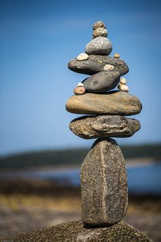 rocks stacked on top of each other in the shape of a pyramid, against a blue sky