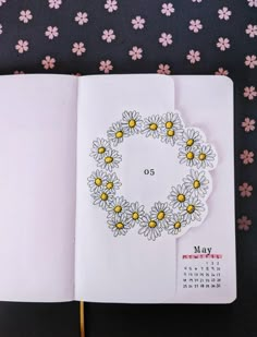 an open notebook with flowers on it and a calendar in the middle that says may