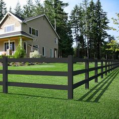 a large house behind a fence in the grass