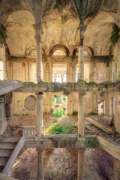 an abandoned building with stairs and windows