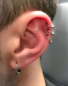 a close up of a person wearing some kind of ear piercings on their ears