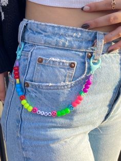 a woman is wearing a colorful bracelet with beads on her waist and the bottom half of her jeans