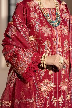 a woman wearing a red dress and jewelry