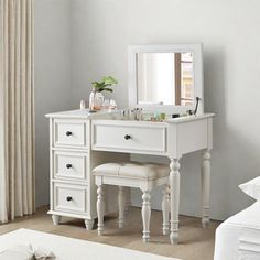 a white vanity with two stools and a mirror