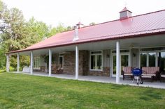 a large house sitting on top of a lush green field next to a blue barn