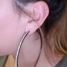 a close up of a person wearing some kind of ear piercing on their left side