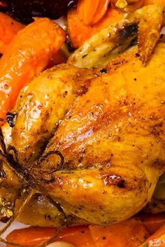 a roasted chicken with carrots and other vegetables