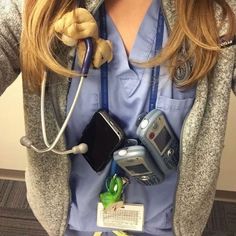 a woman in scrubs is holding some cell phones and earphones on her chest