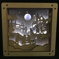 a laser cut christmas scene with children playing in the snow