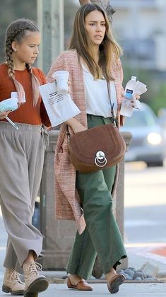 two women are walking down the street