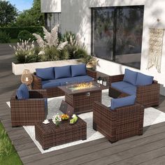 an outdoor living room with wicker furniture and blue cushions on the outside patio area