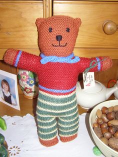 a teddy bear sitting on top of a table next to nuts