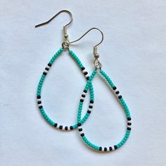 pair of turquoise and black beaded tear earrings on white background with clippings