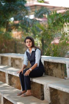 a woman is sitting on some concrete steps