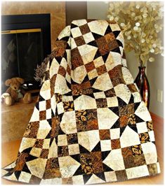 a black and white quilt sitting on top of a chair next to a fire place