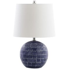 a blue and white table lamp with a white shade on the top, in front of a white background