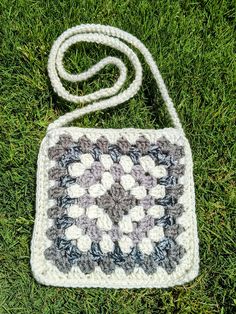 a crocheted bag sitting on top of green grass