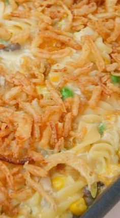 a casserole dish with noodles, corn and green onions in it on a table