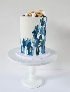 a blue and white cake with gold decorations