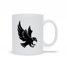 a black and white coffee mug with an eagle design on it's left side