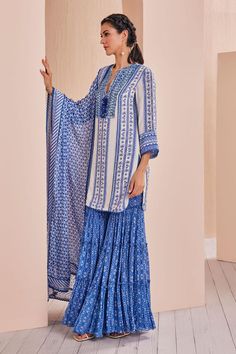 Blue embroidered crepe kurta with floral patterns. Comes with tiered sharara and a georgette dupatta, adorned with delicate lace and a printed border.
Components: 3
Pattern: Printed, Embroidered
Type Of Work: Floral
Neckline: Notched
Sleeve Type: Three Quarter
Fabric: Crepe, chiffon, georgette, chanderi
Color: Blue
Other Details: 
Tasseled neckline
Lace hem kurta
Occasion: Sangeet - Aza Fashions Unstitched Blue Bohemian Sets, Unstitched Bohemian Sets In Blue, Blue Bohemian Unstitched Sets, Blue Bohemian Sets Unstitched, Bohemian Blue Anarkali Set For Eid, Blue Bohemian Anarkali Set For Wedding, Bohemian Blue Chanderi Kurta, Blue Anarkali Embroidered Sharara, Blue Bohemian Kurta With Dupatta