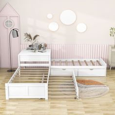 a white bed sitting on top of a hard wood floor next to a pink wall