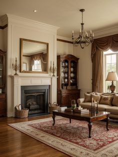 a living room filled with furniture and a fire place under a chandelier on top of a wooden floor