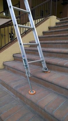 there is a ladder on the steps with an orange object in it's hand