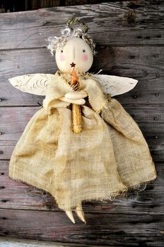 an angel doll hanging on the side of a wooden wall