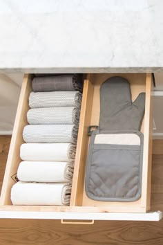 an open drawer with towels and other items in it