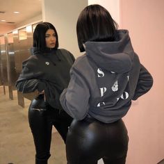 two women in black leather pants and hoodies