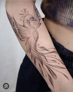 a woman's arm with a bird tattoo on it