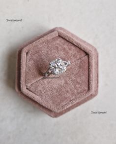 an engagement ring in a pink velvet box