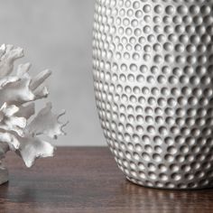 two white vases sitting next to each other on top of a wooden table,