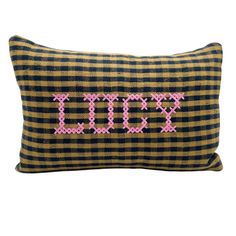 a black and yellow plaid pillow with pink cross stitching on the front that says'xoxo '