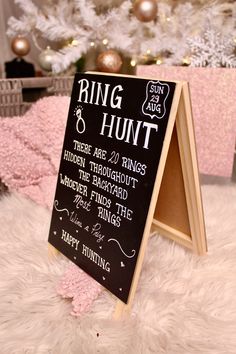 a blackboard sign sitting on top of a white rug next to a christmas tree