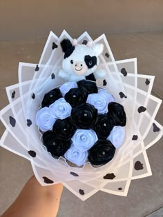 a bouquet of black and white cupcakes with a teddy bear in the middle