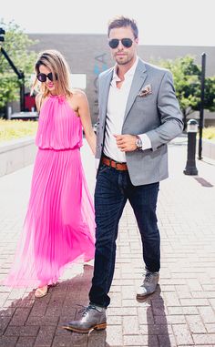 a man and woman are walking down the street wearing sunglasses, one is in a pink dress