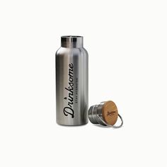 a stainless steel water bottle with a wooden lid and carafe in front of it